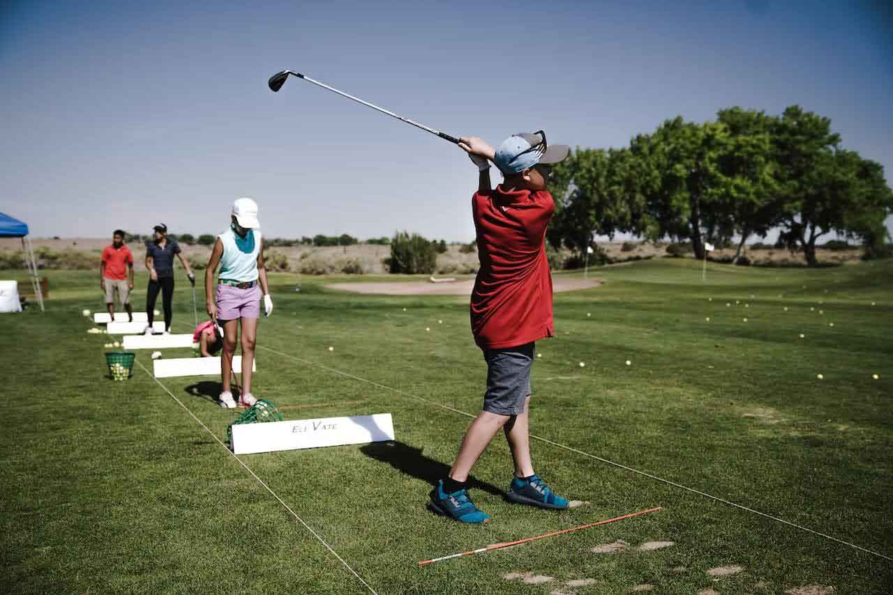 person swinging golf club on field
